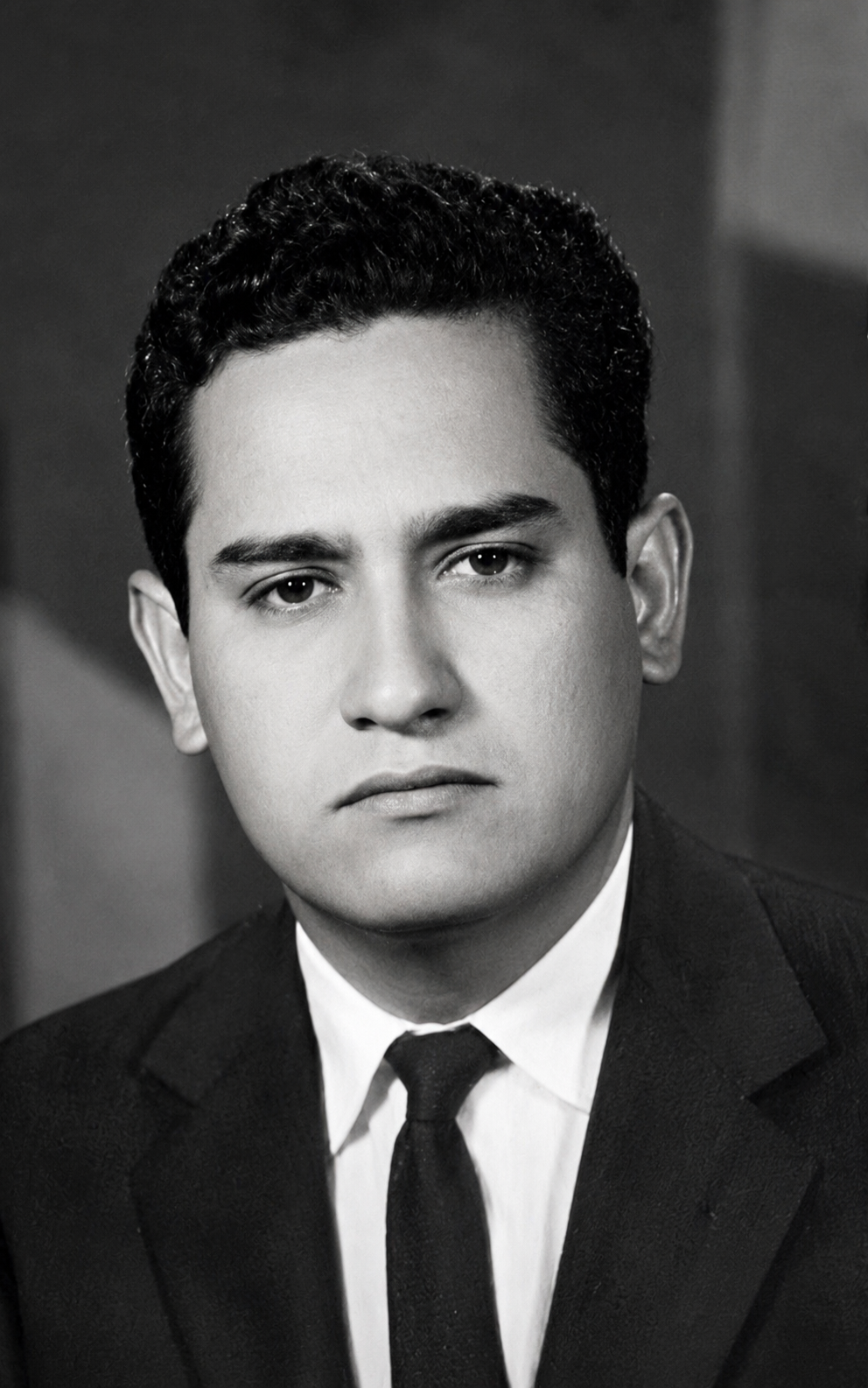 Restauración en blanco y negro del retrato de hombre de cabello rizado, traje oscuro y corbata